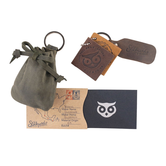 A captivating view of the Mini Medieval Pouch Keychain by Hide & Drink filled with coins, showing its practicality. This tiny bag with keyring is made from full grain leather, emphasizing artisan craftsmanship from La Antigua Guatemala.