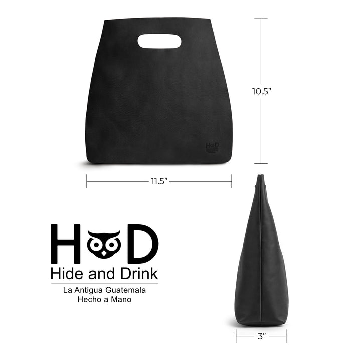 The Hide & Drink Minimalist Boho Handbag displayed alongside everyday items, highlighting its functionality. This rustic purse is perfect for all occasions, crafted from elite Full Grain Leather in La Antigua Guatemala & Oaxaca Mexico.