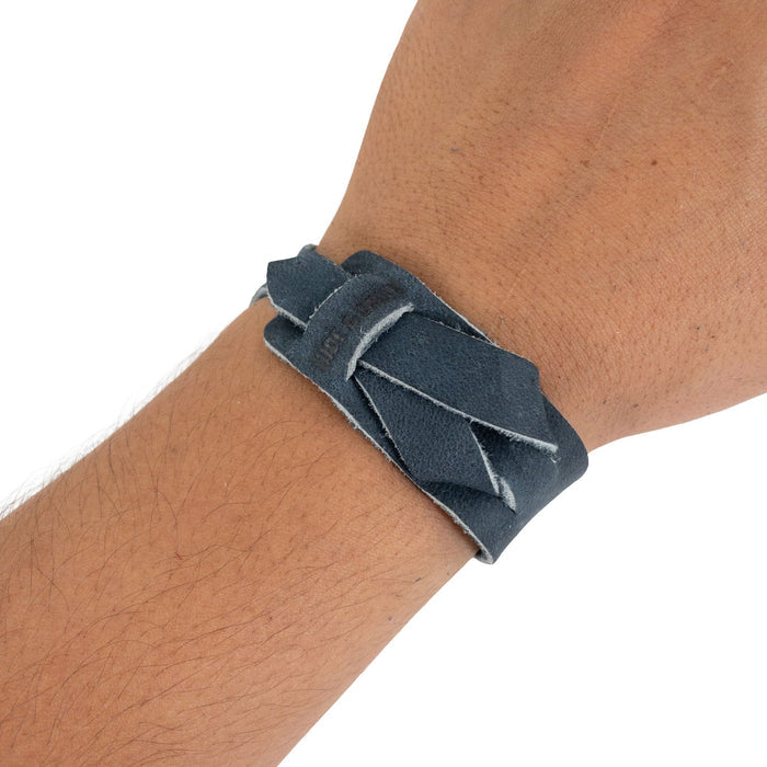 Hide & Drink‚Äôs Minimalist Wristband in navy worn on wrist, exemplifying its stylish design and comfort. Made from full grain leather, this adjustable cuff is a rustic bracelet reflecting StockyardX's artisan craftsmanship from La Antigua Guatemala.