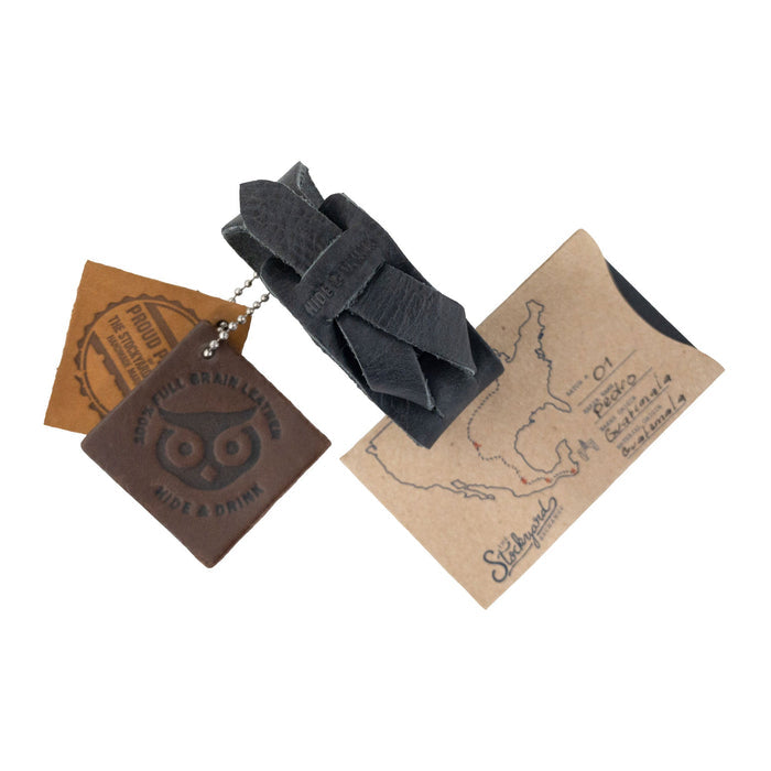Hide & Drink‚Äôs Minimalist Wristband with included leather tags showing quality craftsmanship. This black rustic bracelet features an adjustable strap, embodying the artisan spirit of small batch production in La Antigua Guatemala by StockyardX.