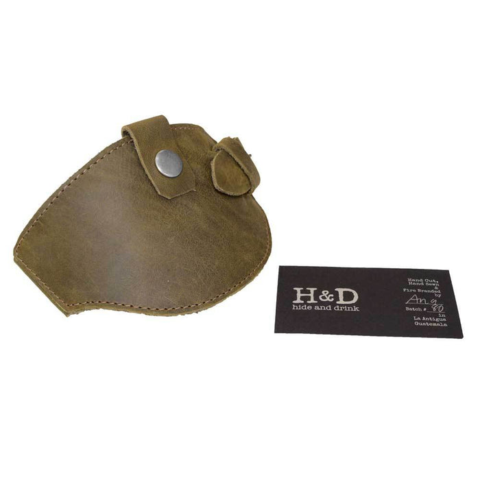 Motorcycle Boot Protector in olive green from Hide & Drink with a business card reflecting its artisan production. This durable shoe cover offers protection from shifter damage, crafted from high-quality full grain leather, emphasizing handmade quality from La Antigua Guatemala.