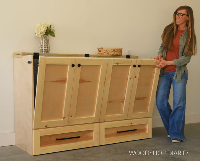 Woodshop Diaries builder demonstrating how to fold out the DIY murphy bed cabinet