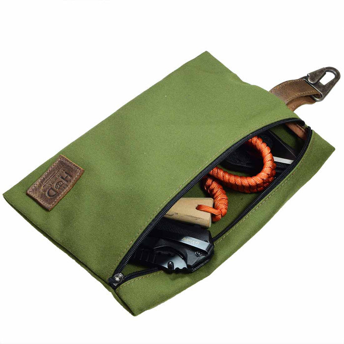 Hide & Drink Outdoor Pouch featuring a Water Resistant Canvas Camping Pouch filled with outdoor gear, showcasing its utility as a storage case and utility bag for outdoor accessories. Crafted with Full Grain Leather, this artisan-made pouch is hand cut and hand sewn, reflecting small batch production in La Antigua Guatemala & Oaxaca Mexico.