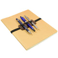 The Pen Holder W/Adjustable Band by Hide & Drink, neatly attached to a notebook with pens in place, exemplifying its use in Home & Office Essentials. Crafted from Full Grain Leather, this item highlights artisan skills from La Antigua Guatemala.