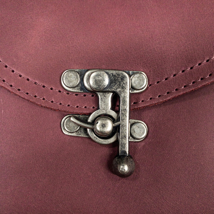 Close-up on the unique vintage clasp of the Petite Vintage Clutch Bag by Hide & Drink, showcasing the meticulous craftsmanship. This small yet stylish handbag is made from durable full grain leather, ideal for use as an elegant evening bag or travel accessory. Proudly artisan-made in La Antigua Guatemala & Oaxaca Mexico.