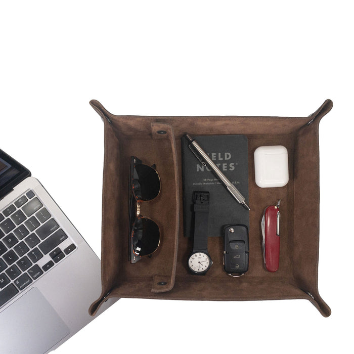 A neatly arranged top view of the Rectangular Catchall with Removable Compartment by Hide & Drink, filled with sunglasses, a notebook, and a pen. This beautiful desktop storage solution is handmade from Full Grain Leather & Sheepskin, showcasing the quality of Small Batch Production, Hand Cut, Hand Sewn, and Fire Branded artistry, crafted with care in La Antigua Guatemala & Oaxaca Mexico.