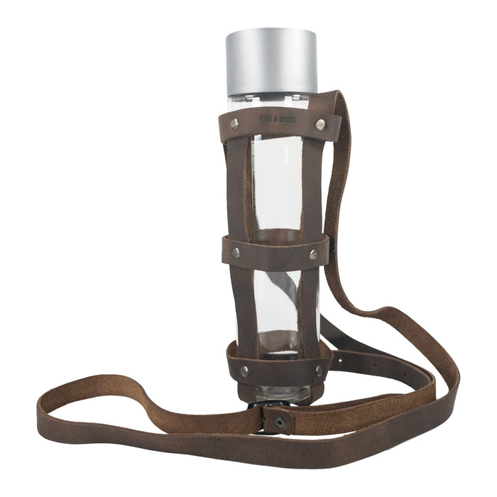 Hide & Drink’s Riveted Bottle Carrier (Bottle Included) showcasing a stylish design made of full grain leather. This travel accessory is perfect for carrying your glass bottle on the go, handcrafted with care in La Antigua Guatemala & Oaxaca Mexico. Riveted Long Bottle Carrier (Glass Bottle Not Included), made using small batch production, hand cut, hand sewn, and fire branded by artisans.