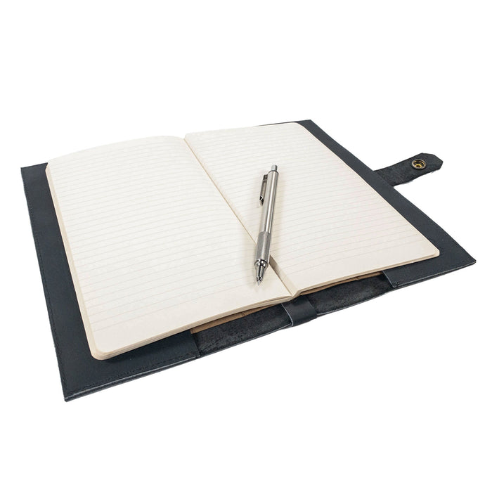 Hide & Drink's Riveted Field Note Cover for Moleskine (5 x 8.25 in.) Notebook NOT Included presented alongside a pen, showcasing its practicality and elegant appeal. Crafted from full grain leather, this cover epitomizes handmade excellence from La Antigua Guatemala & Oaxaca, Mexico.