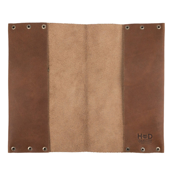 Open view of the Riveted Journal Cover (5 x 8.50 in.) from Hide & Drink, highlighting its smooth interior. Made from full grain leather, this vintage style journal cover is hand cut and sewn by artisans in La Antigua Guatemala & Oaxaca Mexico, ideal for showcasing your note-taking.