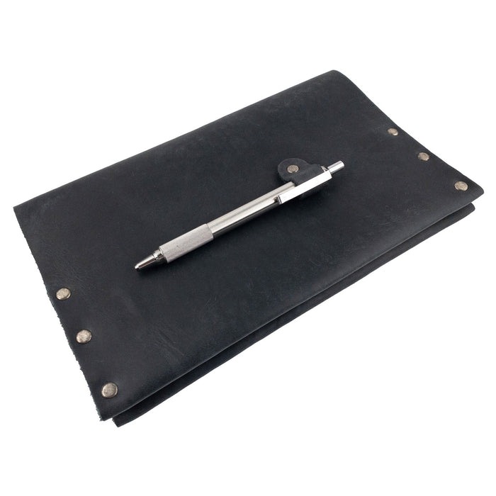 Hide & Drink's Riveted Journal Cover (5 x 8.50 in.) beautifully displayed with a pen, emphasizing its practical use and aesthetic appeal. Crafted from full grain leather, this classic sleeve is perfect for carrying notebooks and reflects small batch production and artisan quality. An essential item for anyone wanting the Riveted Journal Cover for Notebook (5 x 8.50 in.) (Notebook Not Included), merging functionality with style.