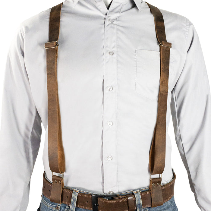 Model wearing Riveted X Back Suspenders with Belt Loops by Hide & Groom, highlighting the adjustable straps and classic style suitable for casual or formal attire. Built from heavy duty harness material and full grain leather, this handmade product is perfect for various occasions.