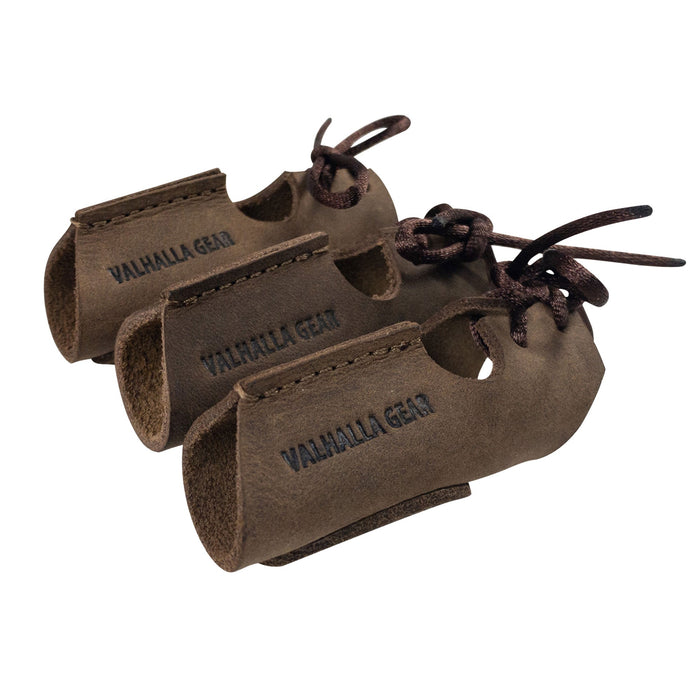 The Set of 3 Finger Protectors for Archery by Valhalla Gear displayed together, highlighting their smooth full grain leather texture. These finger guards are essential archer accessories suitable for recurve bows and shooting targeting. Crafted through small batch production techniques, they are hand cut and hand sewn, featuring artisan quality and fire branding, handmade in La Antigua Guatemala.