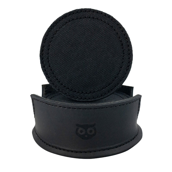 A single circular coaster displayed on a leather holder, from the Set of 8 Circular Coasters for Drinks by Hide & Drink. This handmade piece from Waxed Canvas and Full Grain Leather provides Glass & Cups Stain Protection. Discover the craftsmanship of StockyardX through these Small Batch Production items, which are Hand Cut, Hand Sewn, Fire Branded, and made Artisan, Handmade in La Antigua Guatemala & Oaxaca Mexico.