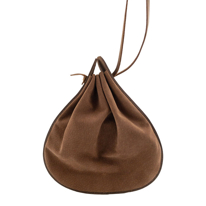 View of Heather's Shoulder Bag, showcasing its rounded design and closure technique. This multipurpose shoulder bag, made from durable full grain leather, is perfect for travel. The product highlights artisan craftsmanship with small batch production, hand cut and hand sewn details, and is fire branded, handmade in La Antigua Guatemala & Oaxaca Mexico.