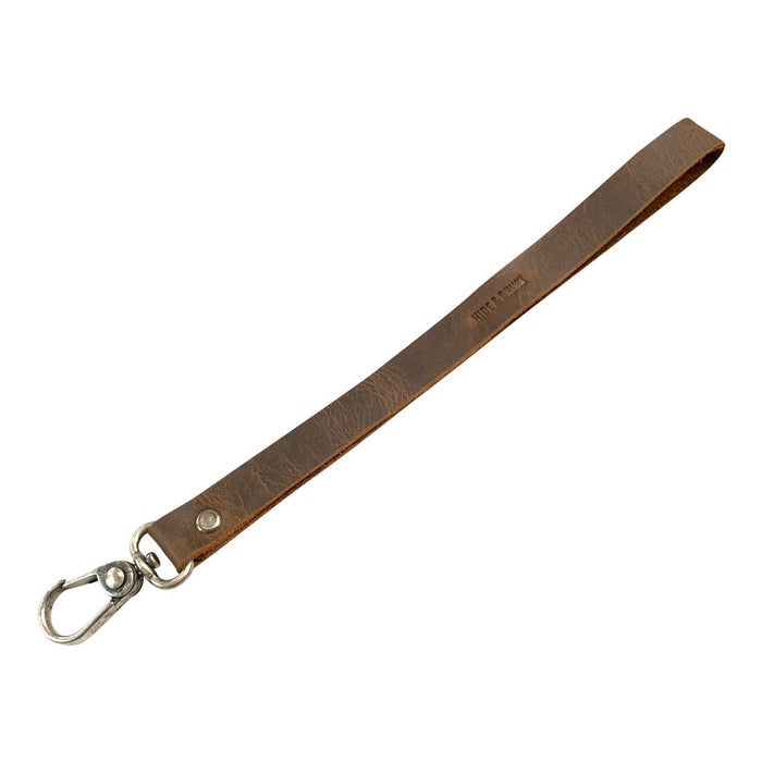 An angled perspective of the Simple Thin Lanyard in Full Grain Leather by Hide & Drink, demonstrating its sleek and functional design. This Simple Thin Lanyard reflects Small Batch Production, Hand Cut, Hand Sewn, Fire Branded, Artisan, Handmade in La Antigua Guatemala & Oaxaca Mexico.