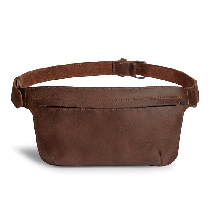 Slim Fanny Pack by Hide & Drink with a rich brown shade showcasing a rectangular design, perfect as a narrow waist bag with an adjustable strap, great for holding phones and small accessories. Made from premium full grain leather, this artisan piece is hand cut and sewn in La Antigua Guatemala.