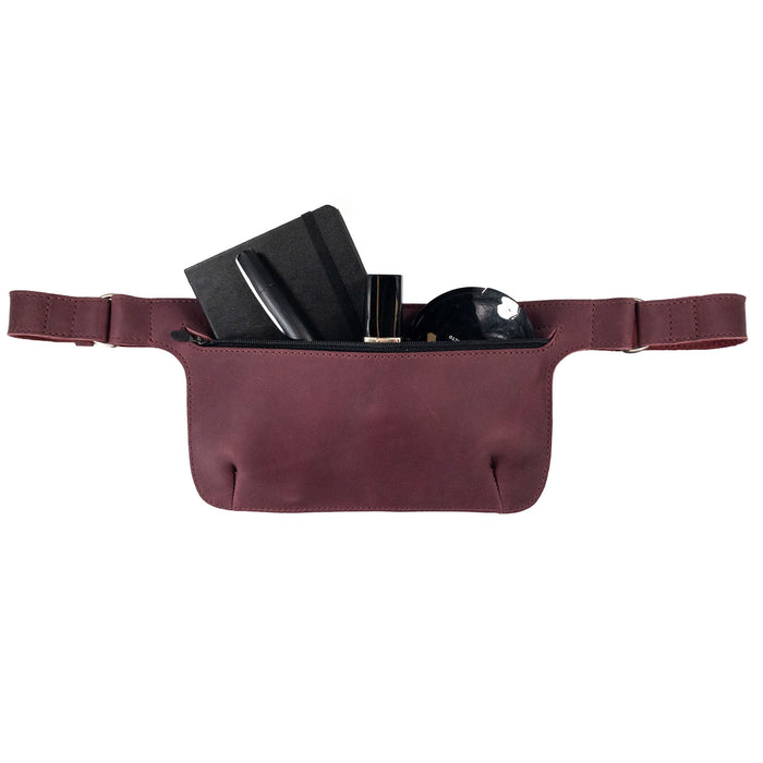 Slim Fanny Pack by Hide & Drink showcasing a color contrast in a maroon leather finish, ideal for a trendy phone holder. This handmade accessory is crafted from full grain leather and reflects artisan craftsmanship.
