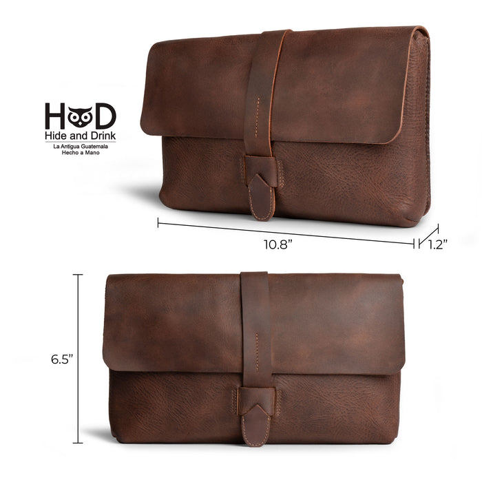Hide & Drink Snapless Clutch Bag displayed with dimensions, crafted from durable full grain leather. This stylish yet functional accessory organizer is hand sewn and fire branded, reflecting the small batch production from artisans in La Antigua Guatemala, making it perfect for everyday use.