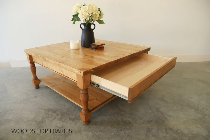 DIY square coffee table with storage drawer pulled open showing full-extension drawer slide and lower open shelf