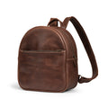 A side view of The Holly Mini Backpack by Austin Genuine, showcasing its rich, full grain leather finish and artisan craftsmanship with tags like Full Grain Leather, StockyardX, Small Batch Production, Hand Cut, Hand Sewn, Fire Branded, Handmade in La Antigua Guatemala & Oaxaca Mexico.