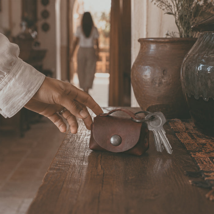 Back view of the Tiny Handbag Keychain by Hide & Drink, highlighting its unique Full Grain Leather texture and key ring holder. A true testament to artisan craftsmanship from La Antigua Guatemala, this keychain is both stylish and functional.