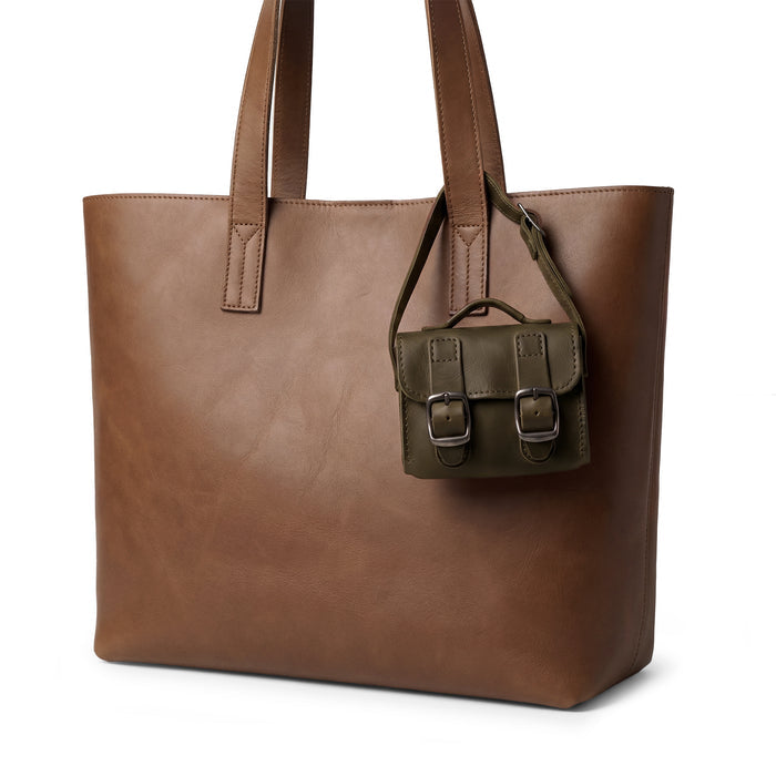 The elegant green Tiny Messenger Bag by Hide & Drink, a unique Mini Messenger Bag Charm crafted from high-quality Full Grain Leather. This artisan piece is perfect as a keychain or handbag accessory, proudly made by hand in La Antigua Guatemala.