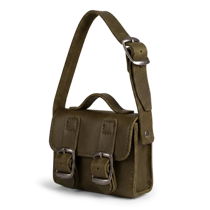 Side view of the green Tiny Messenger Bag by Hide & Drink, spotlighting its Fuller Grain Leather quality. This Mini Messenger Bag Charm is a stylish keychain or a charming addition to handbags, highlighting artisan production in La Antigua Guatemala.