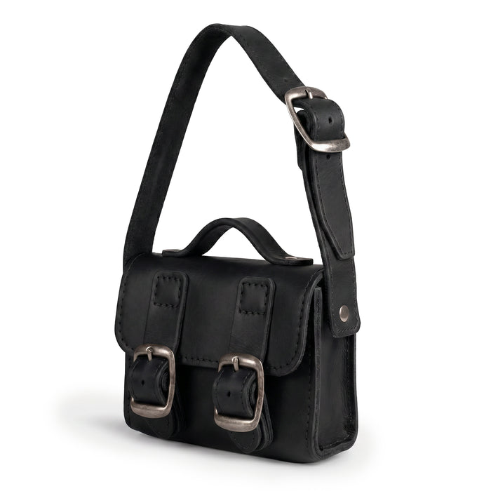 Side view of the Black Tiny Messenger Bag by Hide & Drink, emphasizing the quality and craftsmanship of this Mini Messenger Bag Charm made from durable Full Grain Leather. This artisan piece serves as a charming keychain and reflects handmade excellence from La Antigua Guatemala.