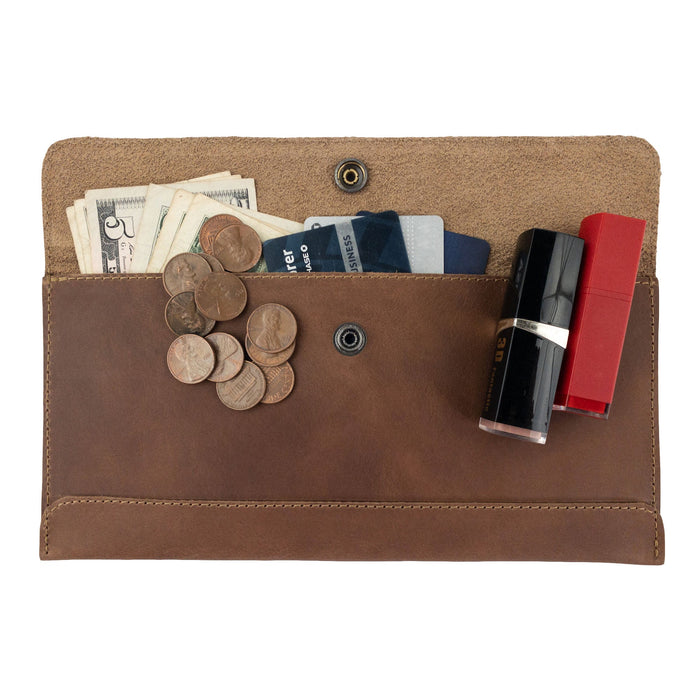 The interior of Hide & Drink's brown Travel Hand Wallet filled with cards and coins, showing its spaciousness and quality craftsmanship in Full Grain Leather. This Travel Wallet is carefully handmade in La Antigua Guatemala & Oaxaca Mexico.