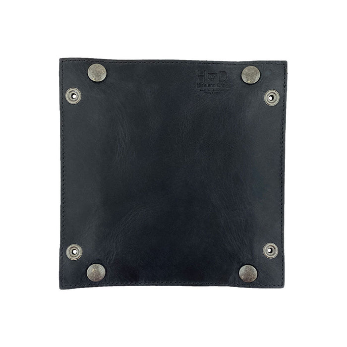 A close-up of the bottom side of the Valet Tray with Sheep Skin by Hide & Drink, highlighting the sturdy brass snaps that contribute to its functionality. This tray is perfect for organizing personal items like change and keys, handcrafted from Full Grain Leather & Sheepskin, showcasing the artisan workmanship from La Antigua Guatemala & Oaxaca Mexico.