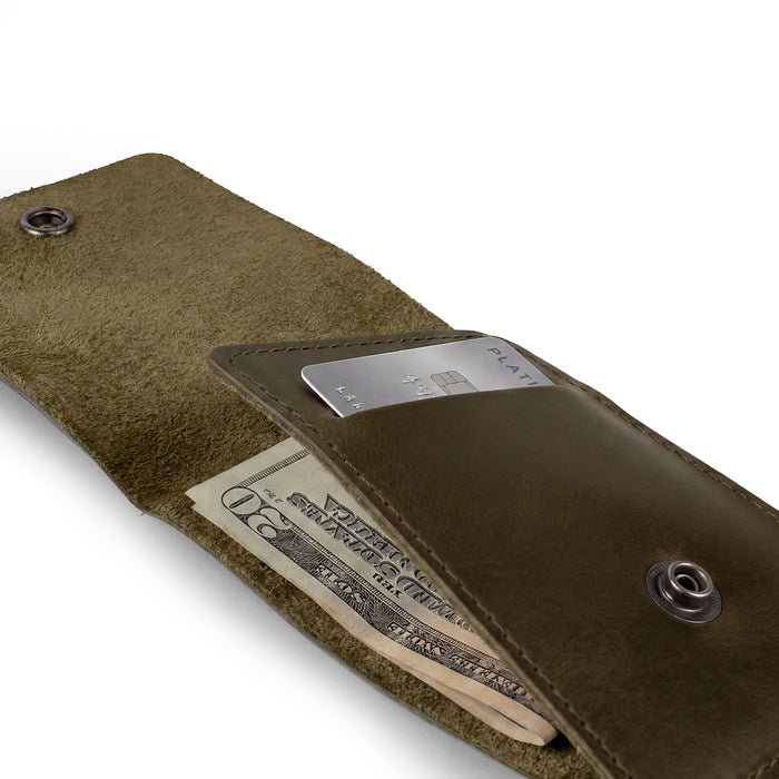 Side view of the green Vertical Wallet by Hide & Drink showcasing its compact profile. This Vertical Front Pocket Wallet with Card Slot provides stylish storage for bills and cards, crafted of full grain leather through small batch processes with hand cut and hand sewn artistry, fire branded for a unique touch. Handmade in La Antigua Guatemala & Oaxaca Mexico.