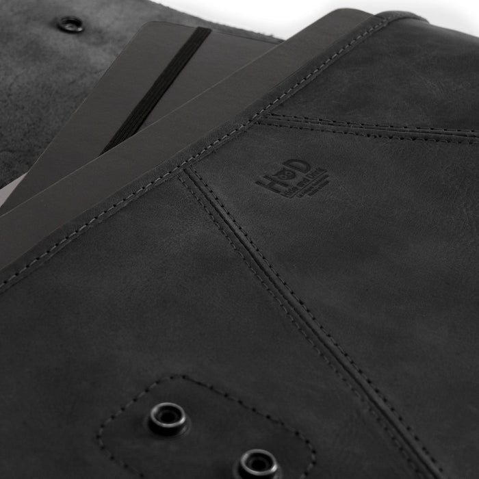 Close-up of the black Vintage Folder Holder XL by Hide & Drink, made from superior Full Grain Leather. This handmade leather folder is ideal for contracts and documents, representing artisan craftsmanship from La Antigua Guatemala and Oaxaca Mexico, designed with both style and practicality in mind.