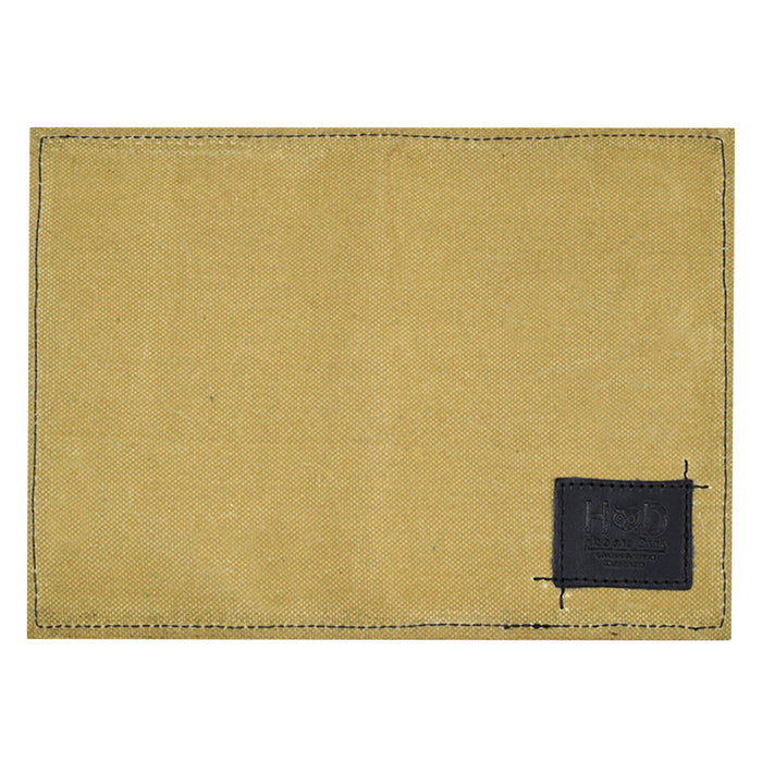 Hide & Drink Waxed Canvas Field Notes Cover presented against an artistic background, highlighting its artisan quality. This durable Wallet Case (3.5 x 5.5 in.) Journal Cover is well-suited for anyone needing a reliable note-taking solution.