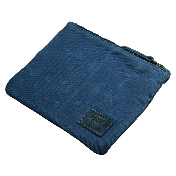 An empty blue Waxed Zippered Pouch from Hide & Drink showcasing its sleek design, perfect as a lightweight case. This multipurpose bag is made using artisan techniques from waxed canvas and full grain leather.