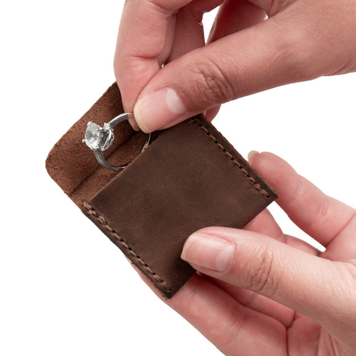 Hide & Drink Wedding Ring Case being held, perfect for storing and showcasing engagement rings. This pouch organizer is a small bearer and slim storage box, made from durable full grain leather, hand cut and sewn by artisans in La Antigua Guatemala & Oaxaca Mexico.