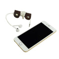 The Wrap Cord Keeper by Hide & Drink displayed alongside a smartphone, illustrating its functionality as a cable organizer holder. Made from full grain leather, this handmade accessory is crafted in small batches in La Antigua Guatemala & Oaxaca Mexico.