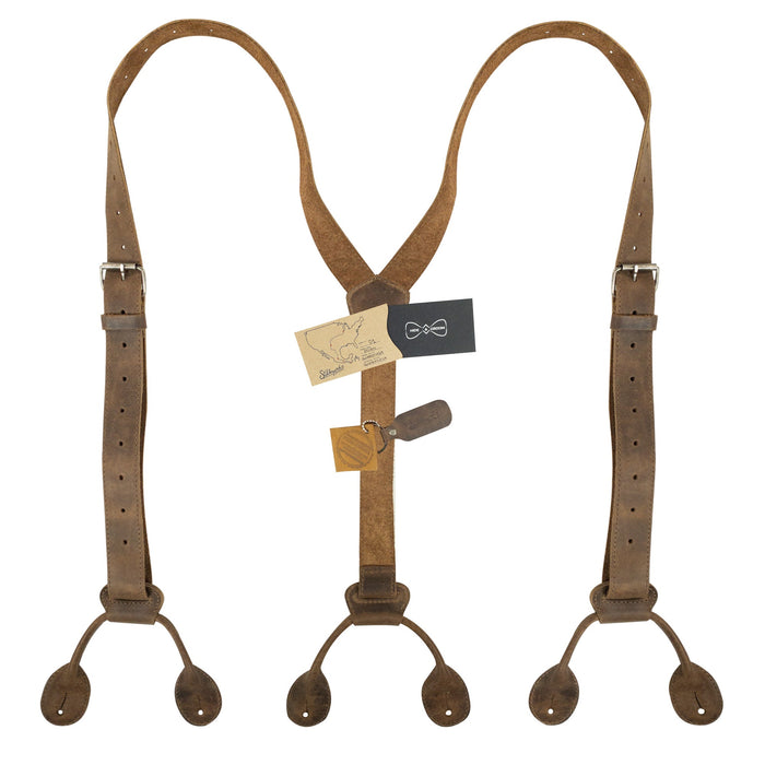 Y Back Button End Suspenders by Hide & Groom, displayed with tags showcasing their artisan craftsmanship. These suspenders are perfect for groomsmen and versatile for any formal event. Made from durable full grain leather, each piece is hand cut and sewn, representing the quality of small batch production from Guatemala.