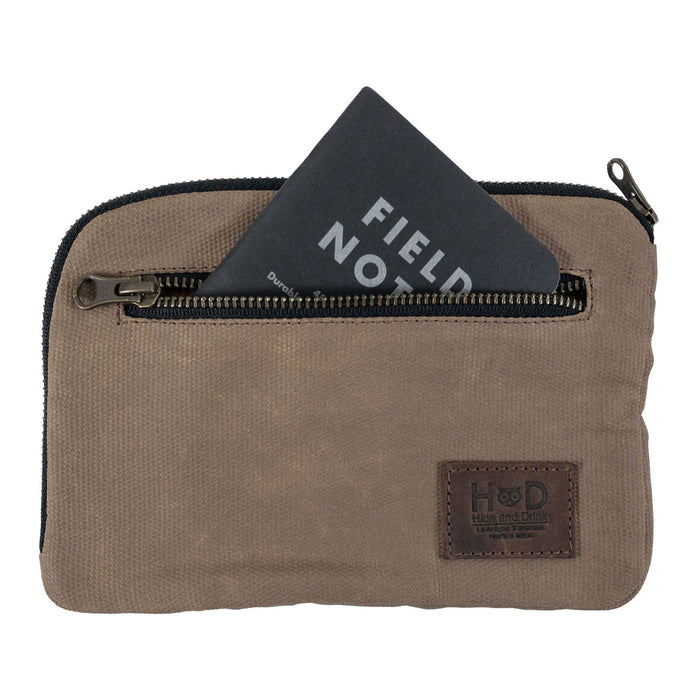 Hide & Drink's brown Zipper Gear Pouch with a Field Notes card, illustrating its practical design for organization and handmade quality from water resistant waxed canvas.