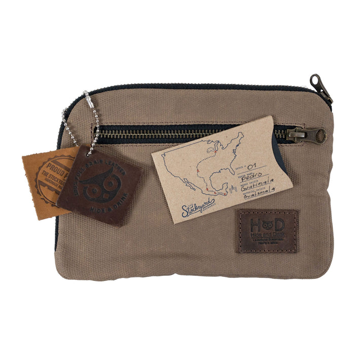 Hide & Drink's Zipper Gear Pouch with artisan craft tags, signifying its handmade quality and unique design, made from durable water resistant waxed canvas.