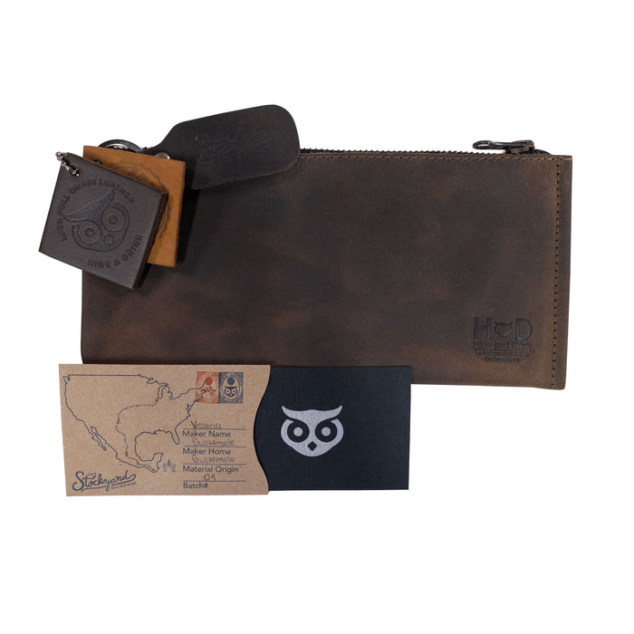 Hide & Drink Zipper Wallet presented with accompanying business cards. This zippered bag is a Rectangular Wallet with Inner Card Slots, crafted from premium Full Grain Leather. This Rustic Card Holder serves as a stylish Travel Accessory showcasing stockyardX‚Äôs Artisan skills, demonstrating Small Batch Production, Hand Cut, and Hand Sewn techniques. Handmade in La Antigua Guatemala & Oaxaca Mexico.